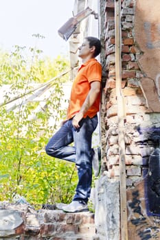 Man standing near old brick wall in summer orange color
