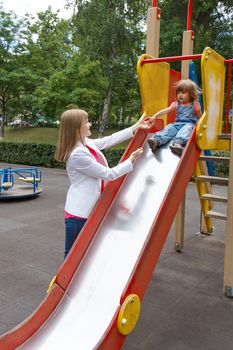 Mother with baby girl riding on hutches in summer