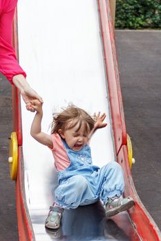 Baby riding on hutches with screw up one eyes