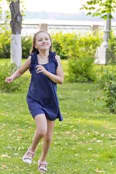 Cute running European girl with disheveled hair in green park