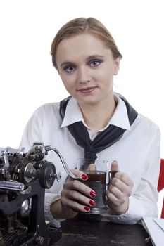 Young girl typist with an old typewriter on a white background