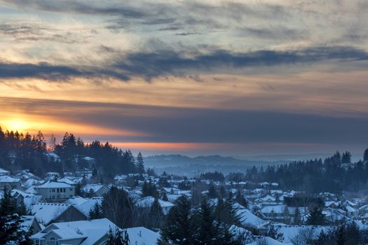 Happy Valley Oregon suburban neighborhood homes covered in snow during sunset