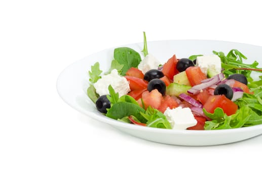 Fragment of a white dish with Greek salad on a light background
