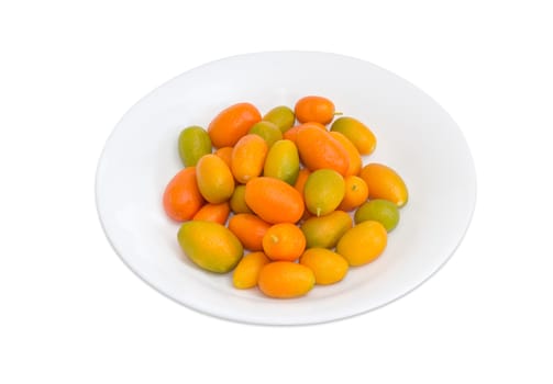 Fresh kumquats on a white dish on a light background
