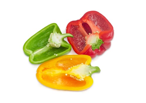 Green, yellow and red fresh bell peppers, cut in half on a light background
