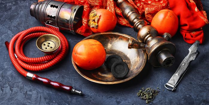 Smoking hookah with the tobacco flavor with the taste of ripe persimmons
