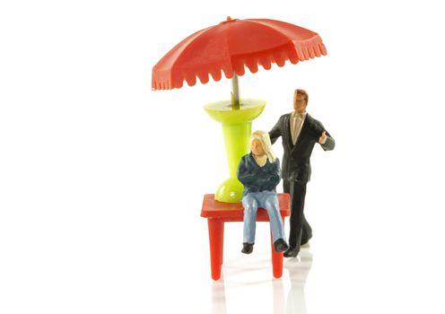 miniature man protect child with umbrella as insurance and protection
