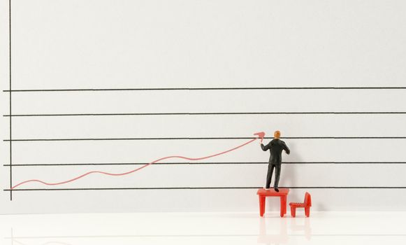 miniature man showing increase and grow of marketing by red graphic line