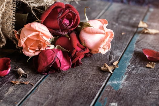 Dry roses on old wooden floor.