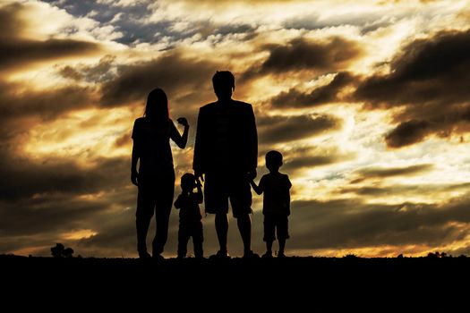 Family with silhouettes at sunset.