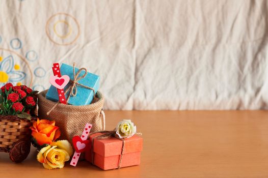 Gift bags and baskets of roses on a wooden floor.