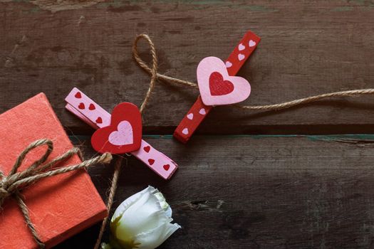 heart-shaped and gift box on a wooden table.