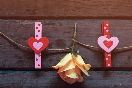 Heart-shaped red and pink with roses on a wooden.