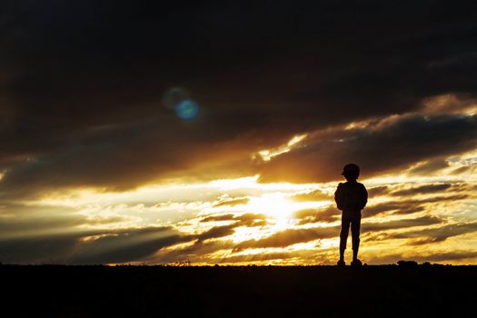 The lonely girl on silhouettes at sunset.