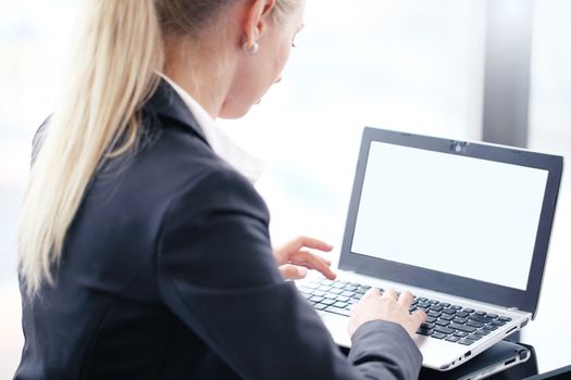 Young business woman working with laptop, white screen for copy space