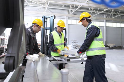 Workers in uniform in CNC machine shop with lathes