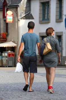 An Intimate couple casually dressed strolling down the street in the evening