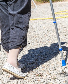 Closeup of Senior woman walking with crutches in her garden