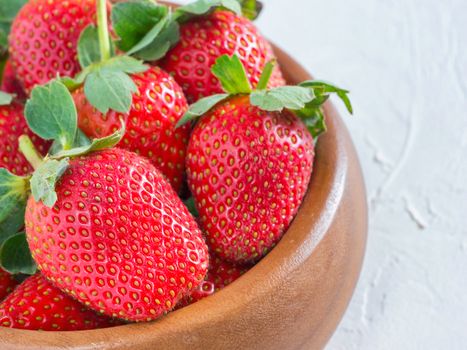 Fresh ripe strawberries in wooden bowl. Strawberry in bowl on oriental white background