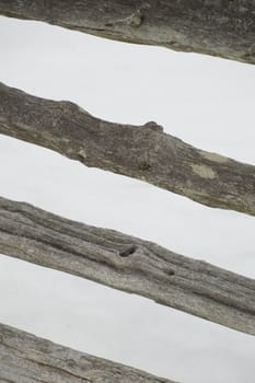 The angled cedar rails are against a white background of snow in winter