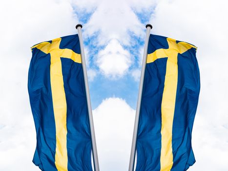 Swedish country flag arranged against a blue sky.