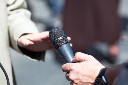 Reporter holding a microphone conducting an media interview