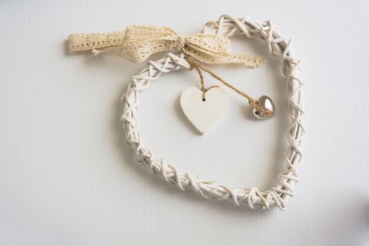 Two wooden hearts placed nicely on a white wood background