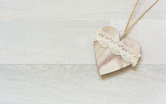 white wooden heart placed nicely on a wood background