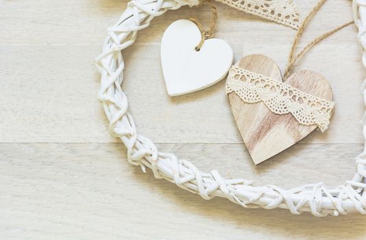 two wooden heart placed nicely on a white wood background