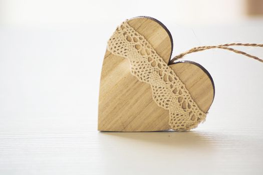 wooden heart placed nicely on a white wood background