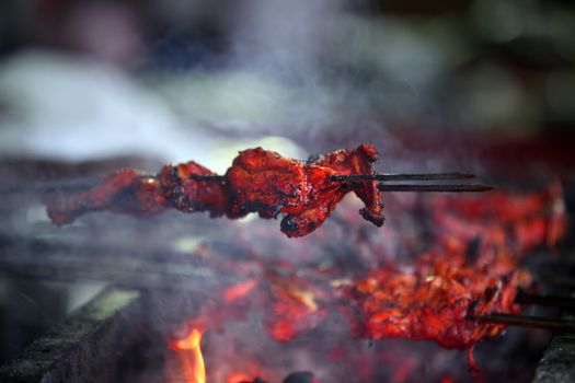 Delicious tandoori chicken on a barbecue covered with Indian delicious spices