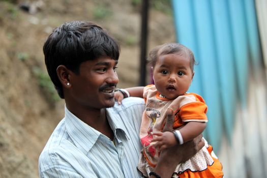 A young Indian father proudly looking at his little girl.