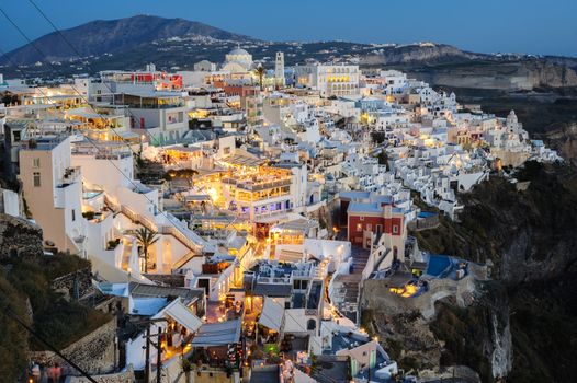 Fira, Santorini island, Greece - April 2016: Illuminated Luxury balcony decks and patios with restaurants of Fira town at Santorini island, just after sunset. Santorini is one of most famous greek resorts situated in Aegean sea at old volcano's caldera.