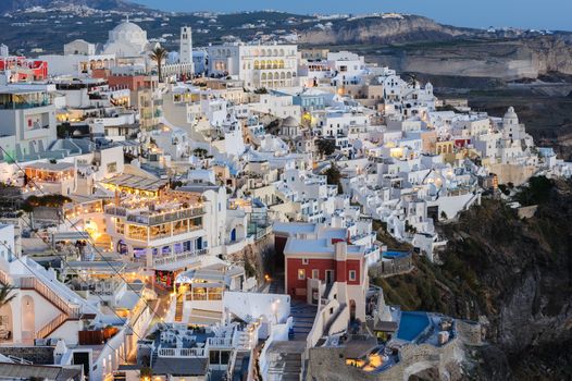 Fira, Santorini island, Greece - April 2016: Illuminated Luxury balcony decks and patios with restaurants of Fira town at Santorini island, after sunset. Santorini is one of most famous greek resorts situated in Aegean sea at old volcano's caldera.