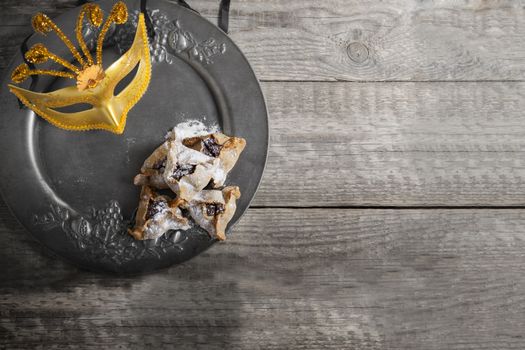 Jewish Pastry Hamantaschen and a mask on a tray