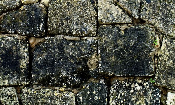 Ancient Stone Wall Background with Square Shape Weathered Blocks closeup Outdoors