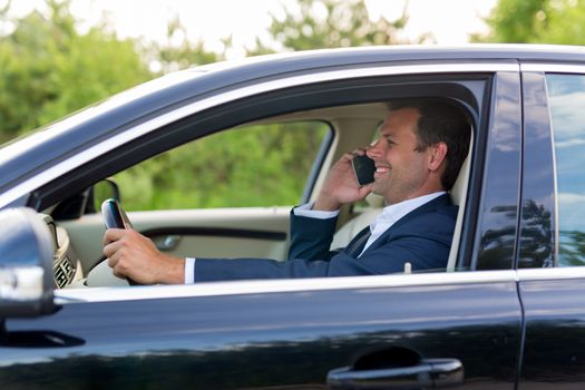 Businessman talking on cell phone while driving, not paying attention to the road and traffic.