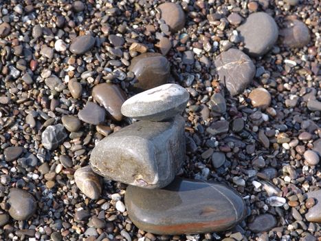 Stacked sea stones. Sea on the background. Contra light