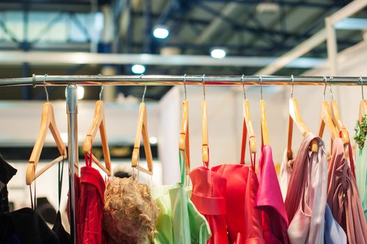 Women colorful dresses hanging in the closet on trempel.