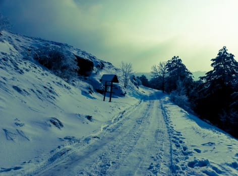 snowy road in the mountains on the edge of the sky