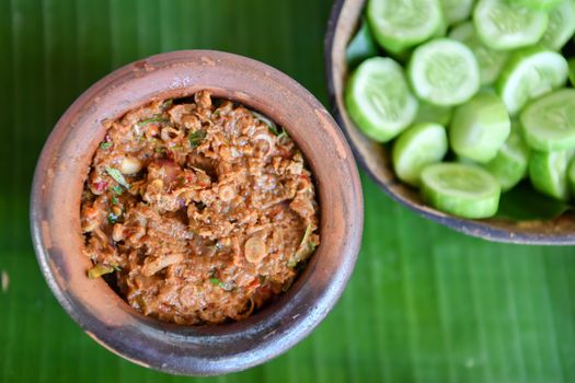 Fermented fish spicy dip in bowl baked clay with fresh cucumber, Thai food. traditional fish preservation,