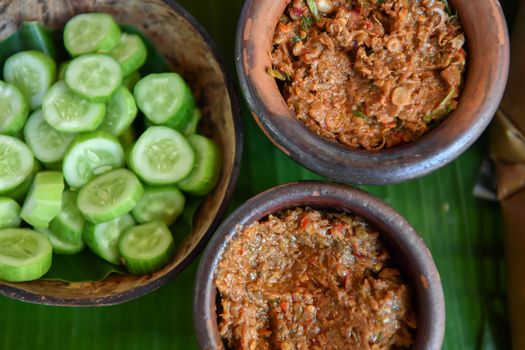 Fermented fish spicy dip in bowl baked clay with fresh cucumber, Thai food. traditional fish preservation,