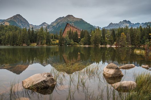 Strbske Pleso Mountain Lake in High Tatras Mountains, Slovakia with Rocks and Grass in Foreground in the Rain