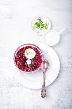 Bowl of beetroot soup with sour cream and eggs.