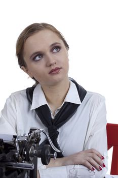 Young girl typist with an old typewriter on a white background