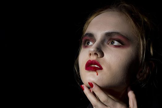 Young girl vampire on a black background