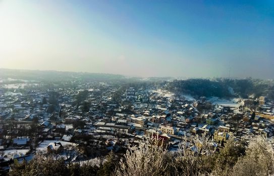 landscape with mountain city is flooded with sunlight in winter