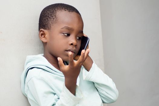 This child questions himself with gestures on the phone with his mother.