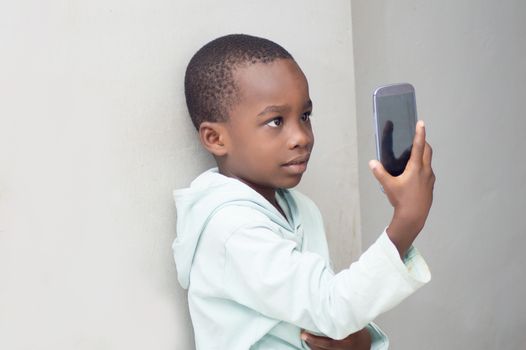 Little boy takes  a picture with his phone .