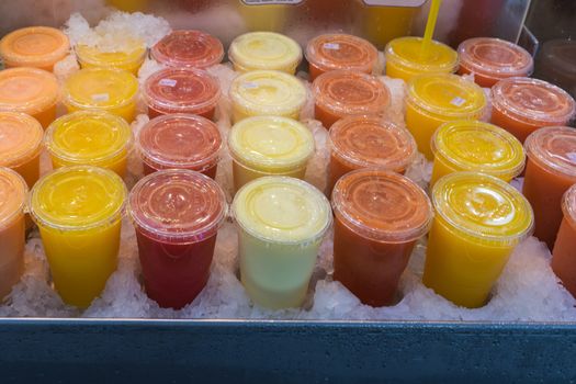 Colorful glasses of fresh fruit juice displayed at the Mercado de La Boqueria in Barcelona. The Mercat de Sant Josep de la Boqueria, often simply referred to as La Boqueria is a large public market in the Ciutat Vella district of Barcelona, Catalonia, Spain and one of the city's foremost tourist landmarks. The market has a very diverse selection of goods.